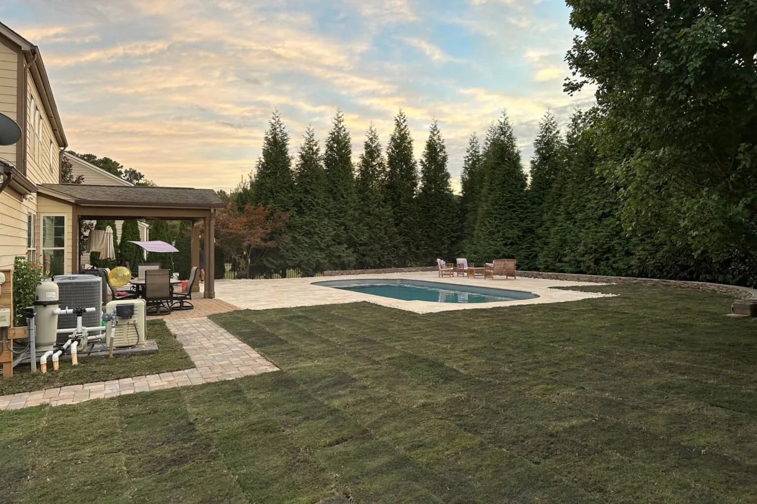 Poolside Paradise with Urban’s completed paver patio, lawn and seating around an existing pool