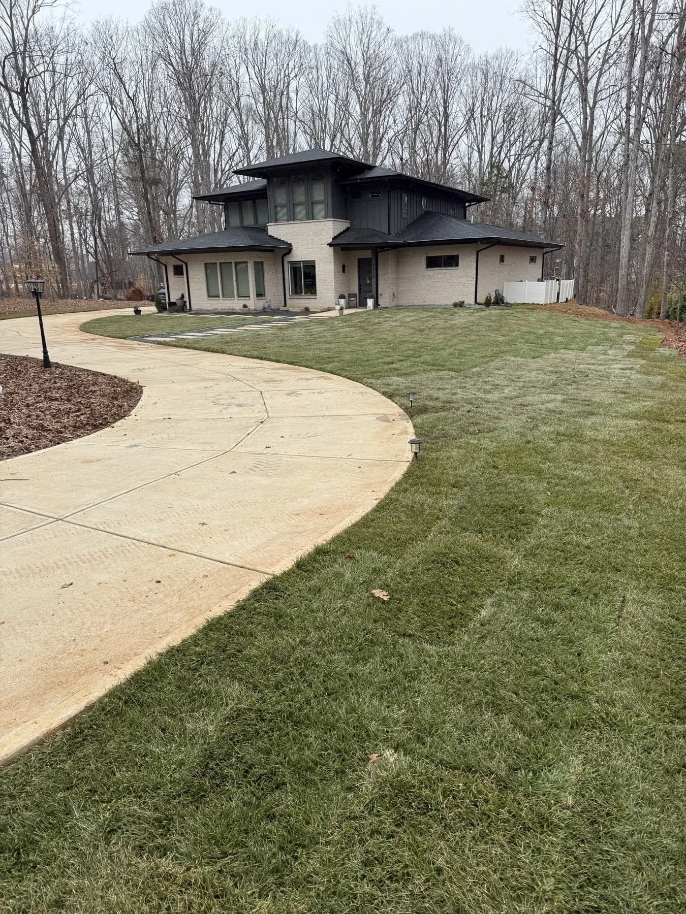 New front-yard sod beside the existing curved driveway at Urban’s Mint Hill yard refresh
