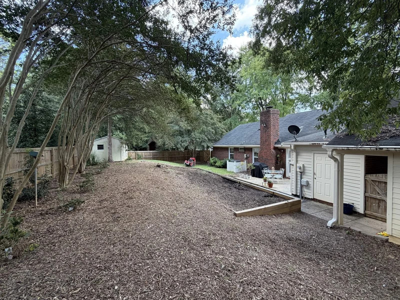 The original timber-edged, woodchip-covered backyard before Urban’s grading and sod renovation