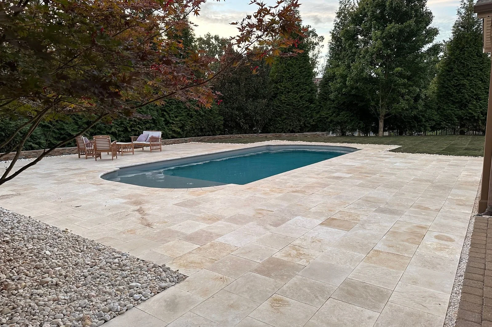 Light-toned paver patio surrounding the pool at Urban’s Poolside Paradise project