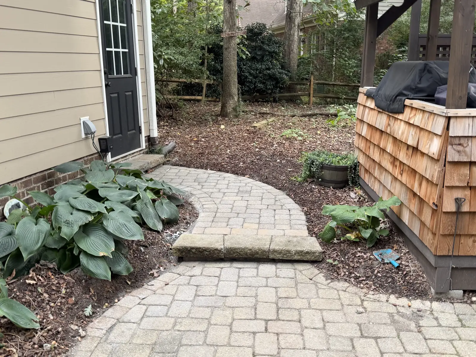 Completed curved paver walkway and step beside the exterior door