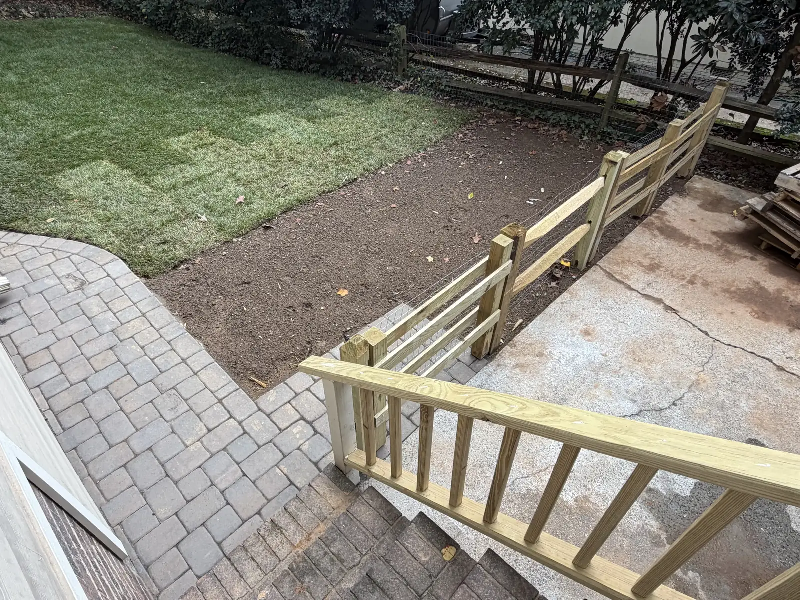 Paver walkway beside the house and newly laid sod near the gate