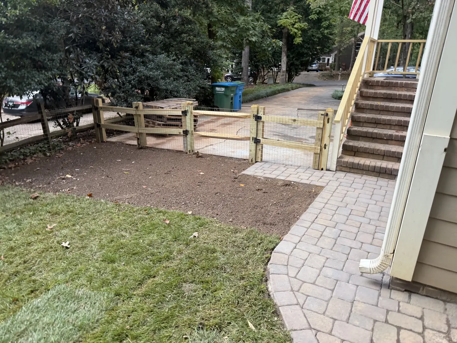 New paver path curving around the house toward the gate, beside fresh sod