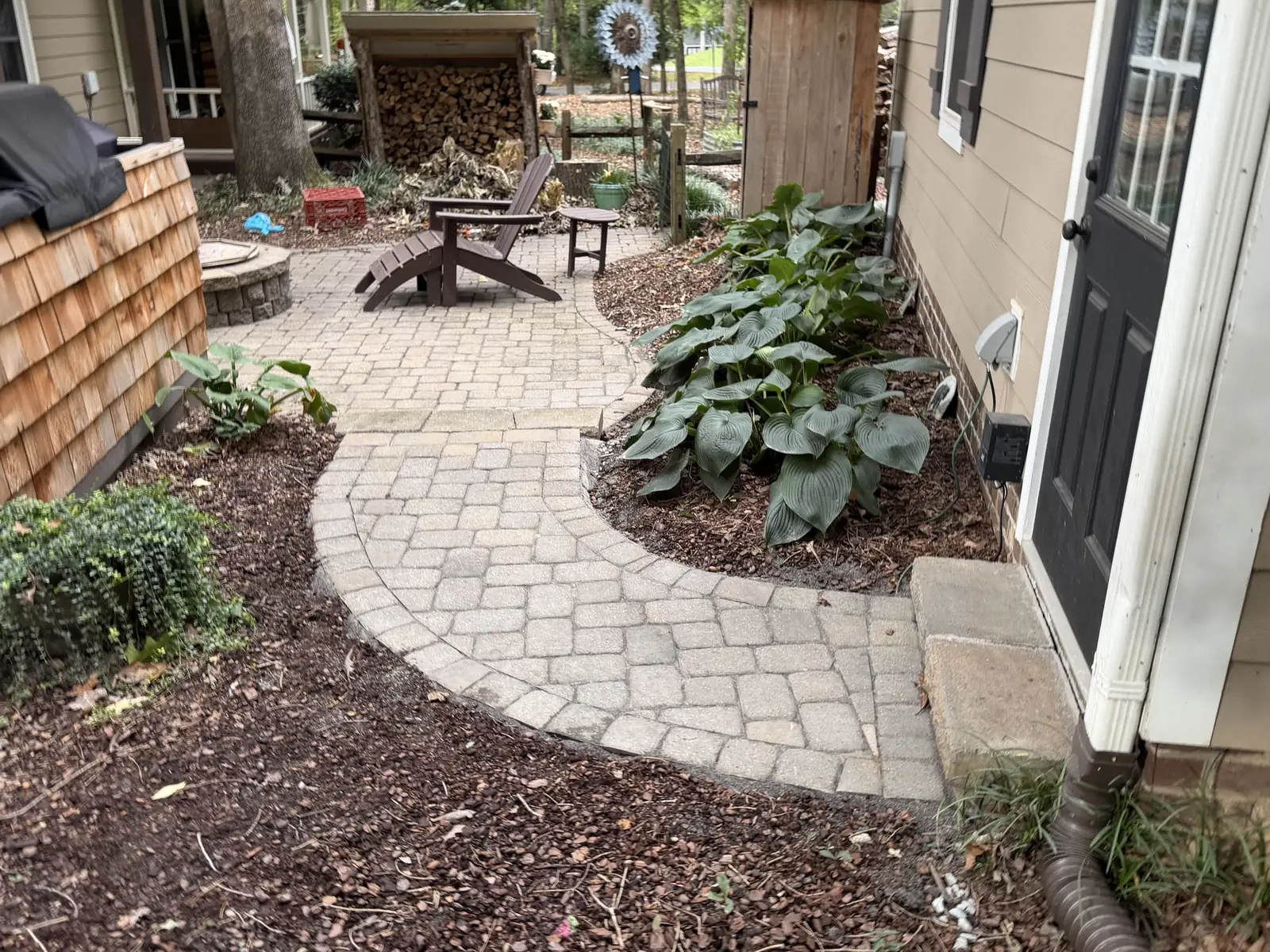 Curved paver walkway connecting the doorway and outdoor seating area