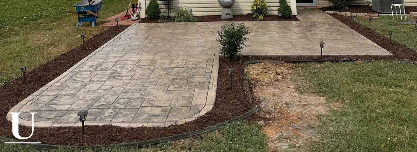 Stamped concrete patio with a rectangular stone-style pattern and curved outside edge