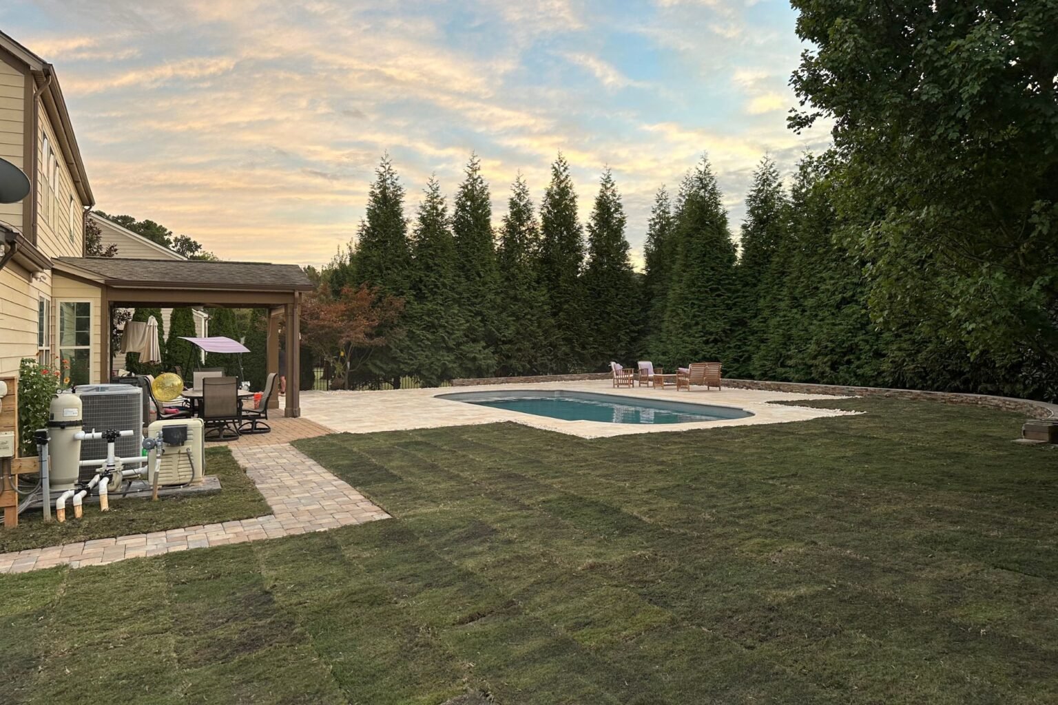 Poolside Paradise – Project 1 Completed Poolside Paradise paver patio, pool, lawn, and outdoor seating in Charlotte