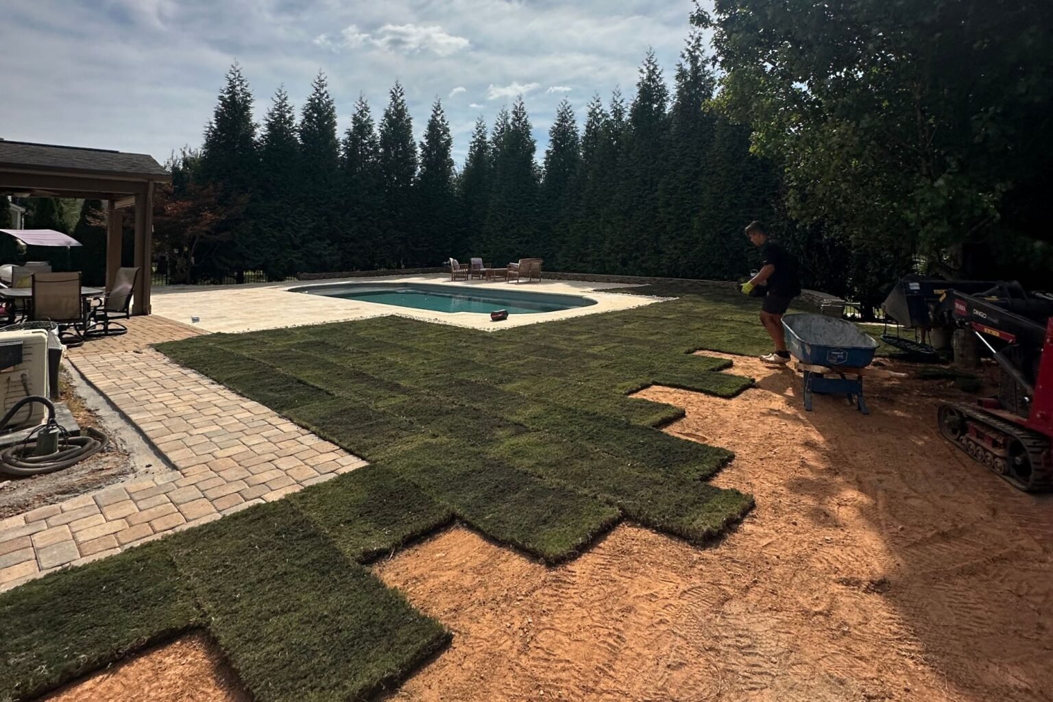 Sod installation in progress beside the Poolside Paradise pool and paver patio