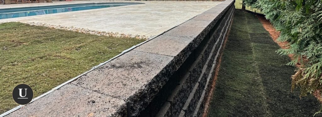 Big long and tall retaining wall holding inground pool on hill in Charlotte nc built by urban landscape & construction
