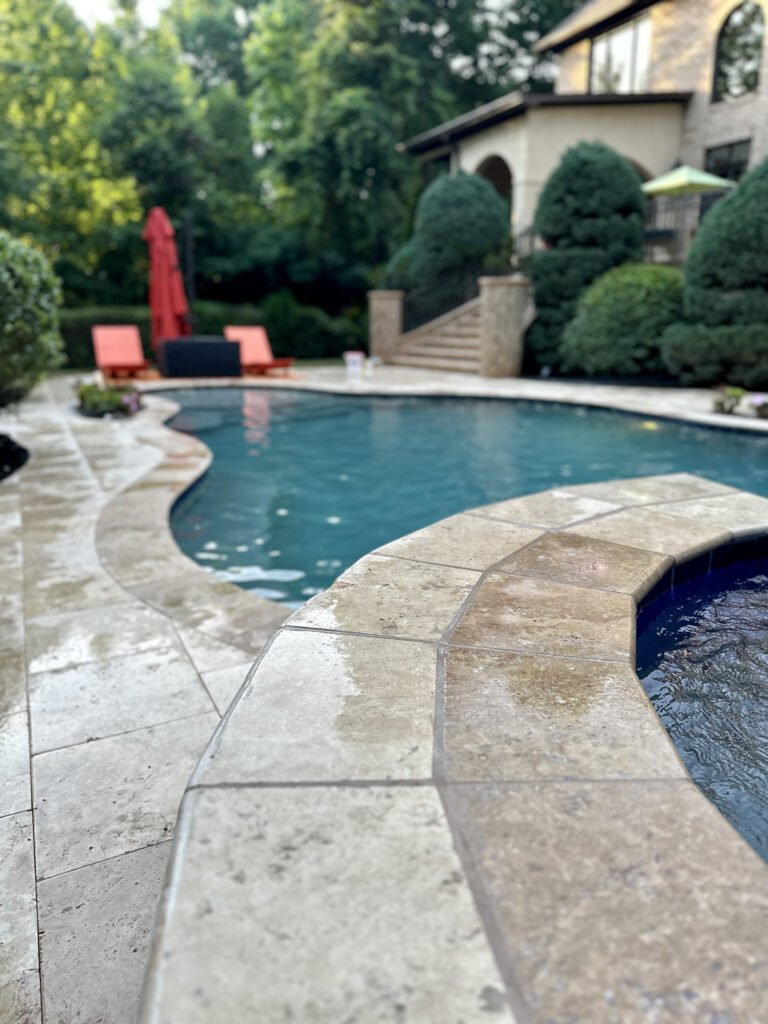 Travertine deck following the curved pool coping