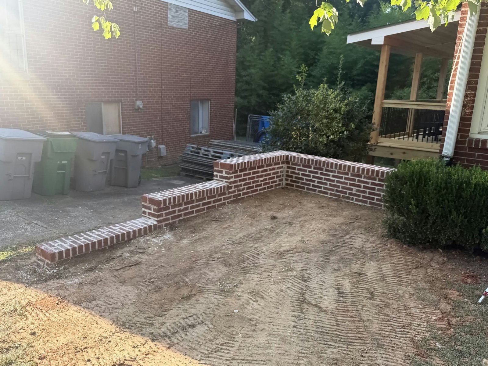 New red brick retaining wall viewed near the front of the brick house