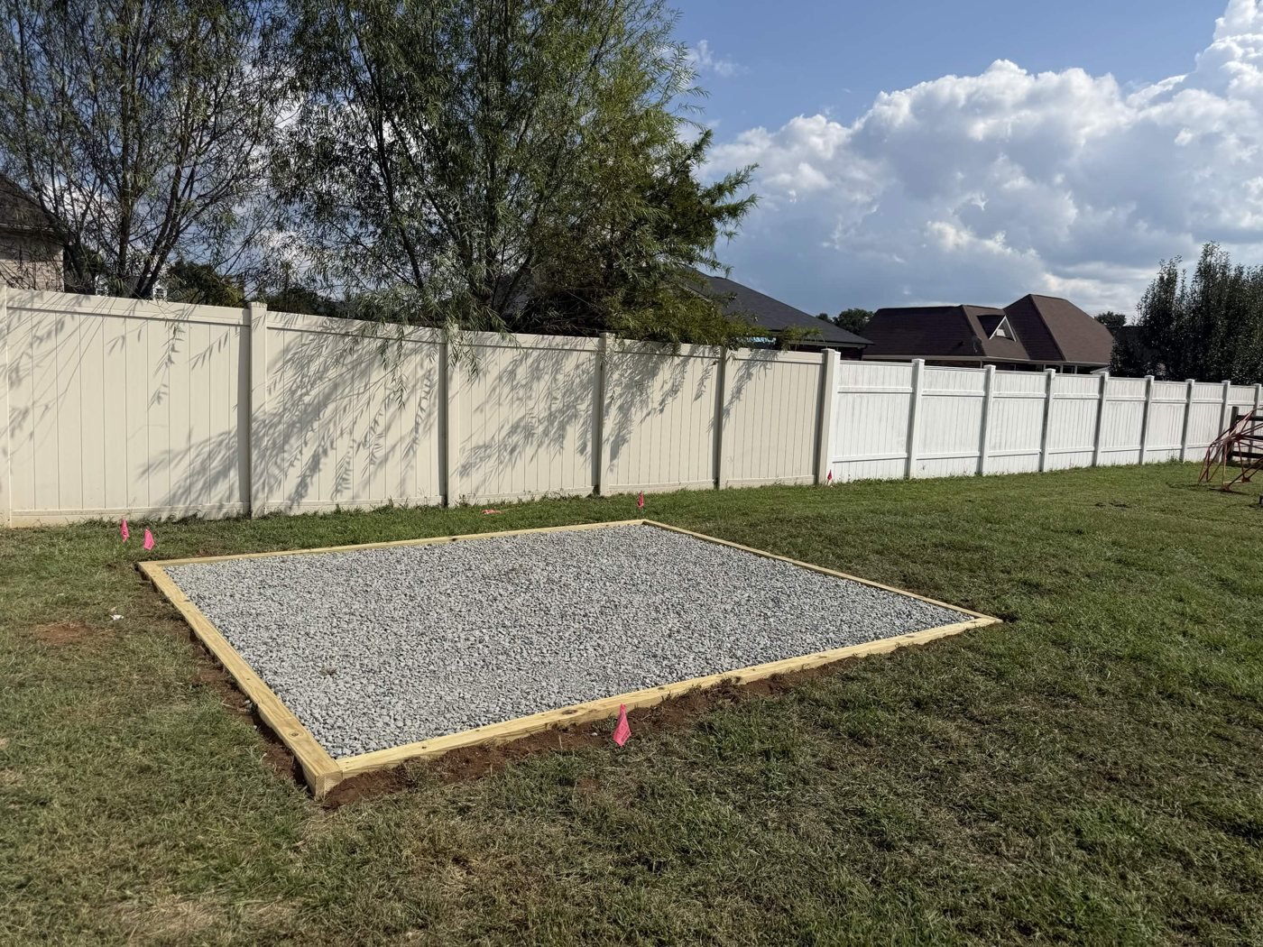 Wide view of the completed gravel pad within the surrounding lawn