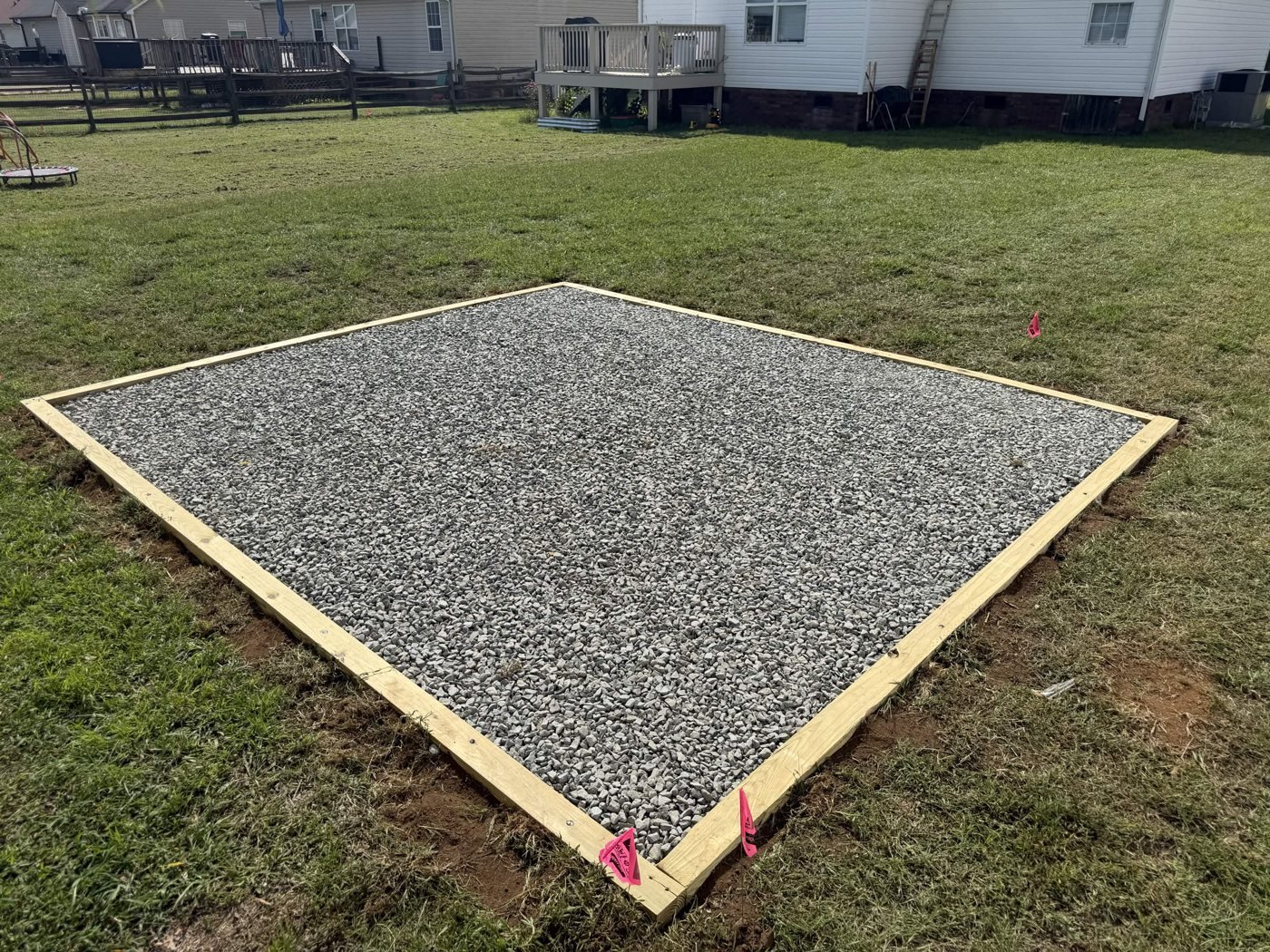 Gravel surface and timber perimeter of the finished backyard pad