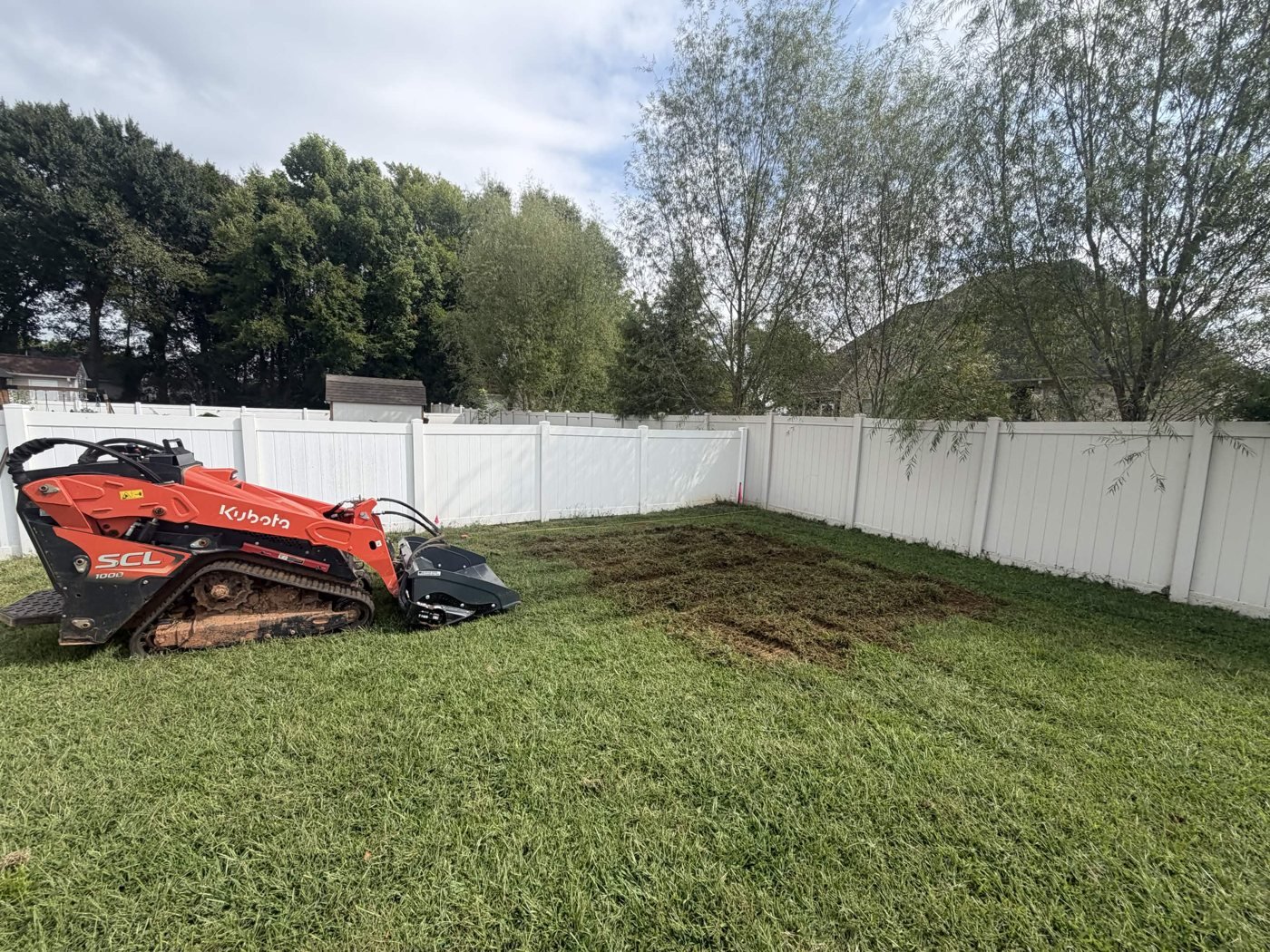Backyard Gravel Pad 3 Tracked loader beside the marked-out area during backyard ground preparation